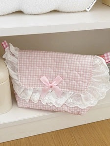 Detail of pink plaid quilted bag with lace trim, heart stitching, and a satin bow