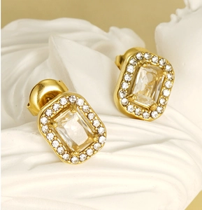 Macro shot of gold-plated double-layer earrings featuring emerald-cut zircon stones