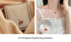 Close-up of golden cherry pendant necklace with red crystals on a silk gift box