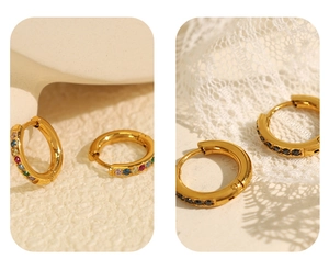 Detailed macro view of gold-plated hoop earrings with micro-inlaid colored and black zircons