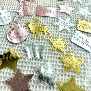 Close-up of laser-cut acrylic Christmas cupcake toppers in mirror gold and silver finishes