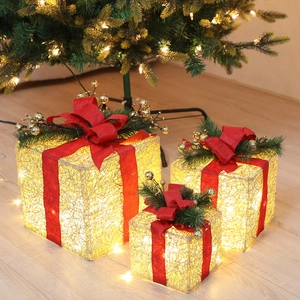 Three-piece glowing Christmas gift boxes with red burlap bows and warm LED lighting detail