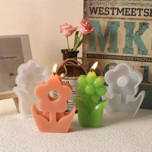 Detalle del molde de silicona de tulipán con velas florales sobre base de madera