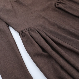 Detailed close-up of dark brown long-sleeve dress fabric with fine waist pleats