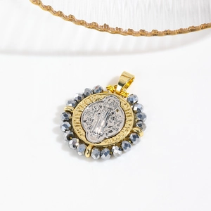 Detailed close-up of a two-tone St. Benedict religious pendant with beaded border