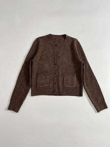 Close-up of brown knit cardigan showing dual patch pockets and ribbed hem details