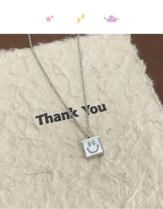 Detail of square mother of pearl pendant with a smile face on silver chain necklace