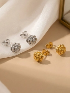 Detailed macro view of 18k gold and silver rose earrings with petal texture and butterfly backs