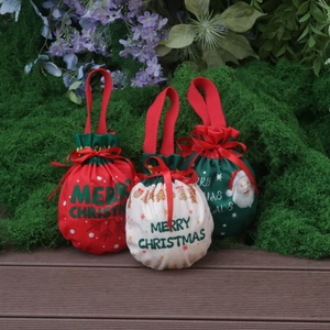 Three festive Christmas drawstring gift bags with Santa patterns and red ribbon handles