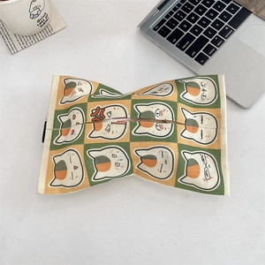 Close-up of green and yellow checkered tissue holder with cute cartoon cat expressions