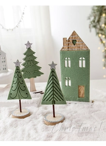 Détail de sapins de Noël en feutre et miniatures de maison en bois avec lumières de fête