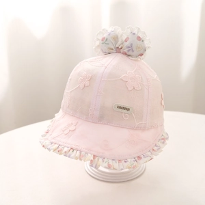 Détail d'un chapeau de soleil rose pour bébé en dentelle avec broderie florale