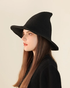 Detail shot of black knitted witch hat showing soft wool texture and pointed brim style