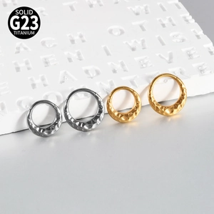 Detail of G23 titanium rings with hammered texture in gold and silver finishes