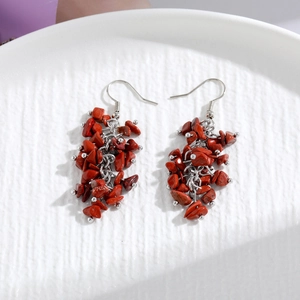 Handmade red natural crystal stone tassel earrings with silver hooks on white tray