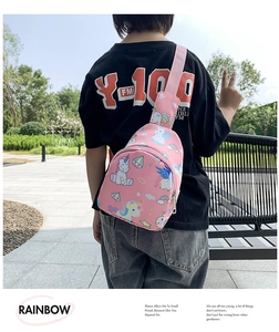 Pink kids chest bag with colorful unicorn prints shown on a young model outdoors