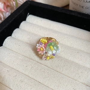 Dettaglio dell'anello floreale fatto a mano con perle in resina nella scatola