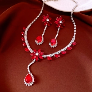 Detailed close-up of zircon flower pendant necklace and earrings on brown silk fabric