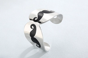 Close-up of polished stainless steel open bangle with black mustache pattern details