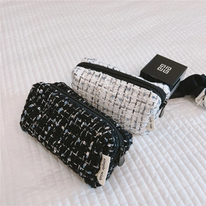 Detail of tweed cosmetic bags with metallic zippers and woven fabric labels