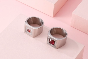 Close-up of red zircon silver rings with micro-set diamonds on pink geometric stairs