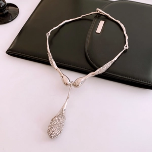 Gros plan d'un collier pendentif en métal liquide avec strass brillants sur cuir noir
