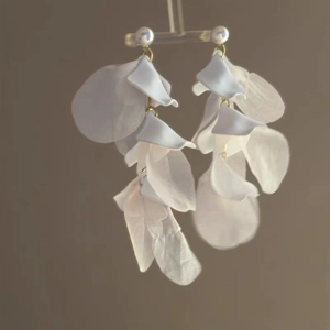 Detail of white organza flower petal earrings with elegant pearl studs and gold loops