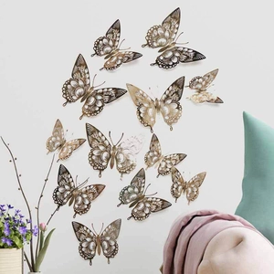 Detailed view of hollow gold butterfly wall stickers on a clean white surface