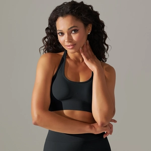 Detail of black seamless halter sports bra with ribbed hem on a professional model