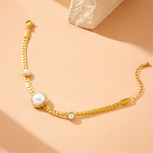 Close-up of a gold-plated pearl and rhinestone bracelet with lobster clasp detail