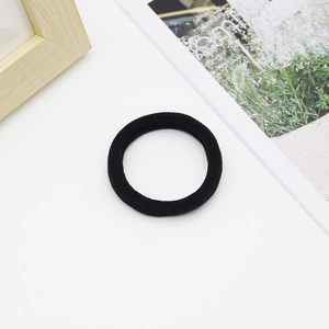 Close-up of seamless black elastic hair ties with woven texture on a white surface