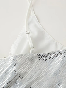 Dettaglio macro delle paillettes argento e della spallina bianca regolabile del vestito