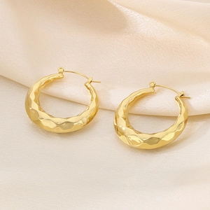Detailed macro view of 18K gold plated U-shaped earrings with hammered metal texture