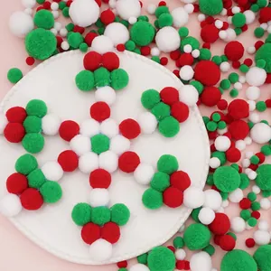 Christmas DIY pompom balls in red white and green arranged in a snowflake shape