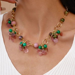 Detail shot of vintage geometric round stone necklace with colorful beads on a model
