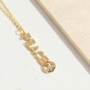 Detailed macro of gold PEACE pendant with sparkling rhinestones and peace sign symbol
