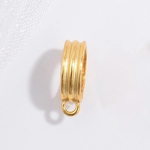 Detailed view of a gold-plated striped pendant clasp with ring on white mesh background
