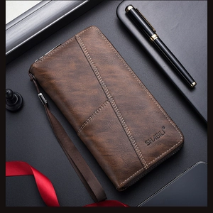 Close-up of vintage brown long wallet with leather texture, white stitching and strap
