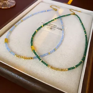 Collier en acier titane avec perles à facettes émeraude et bleu et accents dorés
