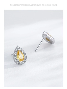 Macro shot of S925 sterling silver drop earrings with yellow zircon and white diamonds