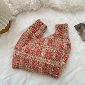 Detailed view of pink checkered plush tote bag on white fabric for winter fashion style
