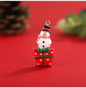 Detailed view of a Christmas resin snowman pendant sitting on a red polka dot gift box