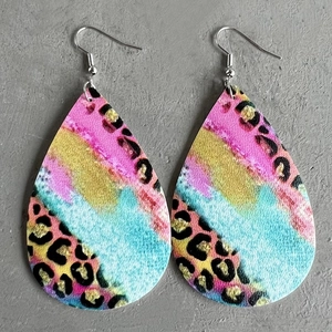 Dettaglio di orecchini in pelle a goccia con stampa leopardata colorata e motivi astratti