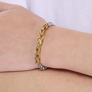 Detail of two-tone gold and silver Byzantine chain link bracelet on a wrist