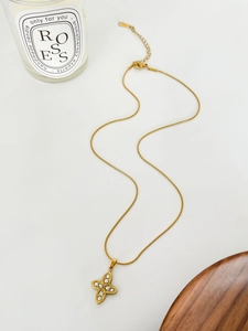 Vue macro du collier trèfle en or 18 carats avec zircon et détails de chaîne serpent
