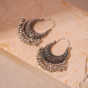 Boucles d'oreilles ethniques bohèmes argentées avec pompons et motifs ajourés vintage