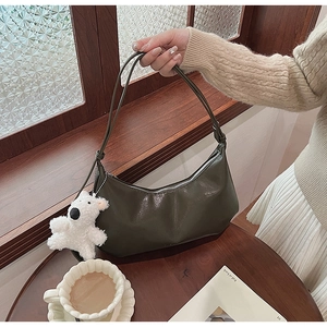 Detail of dark green PU leather hobo bag with cute white plush bear charm accessory