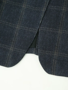 Detail view of the navy plaid blazer hem and high-density textile fabric texture