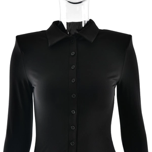 Detail of black long sleeve polo dress featuring button-up collar and ribbed texture