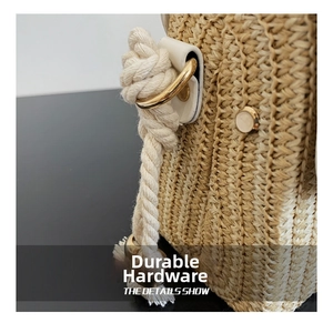 Detail shot of durable metal hook and thick cotton rope strap on straw box bag